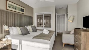 A modern hotel room with a large bed, a desk, a chair, a wardrobe, and a ceiling fan. - The Pool Resort Kingscliff - 1BR with Hinterland Views (5312) - Holiday Management Co. (Tweed)