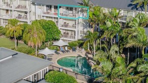 A hotel with multiple floors, a swimming pool, and lush greenery. - The Pool Resort Kingscliff - 1BR with Hinterland Views (5312) - Holiday Management Co. (Tweed)