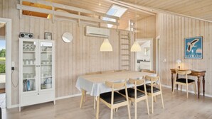 Un comedor con mesa de madera, sillas e iluminación colgante.