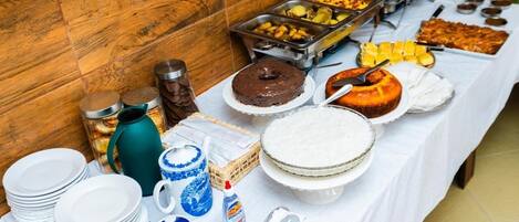 A buffet table with various food items and serving utensils.