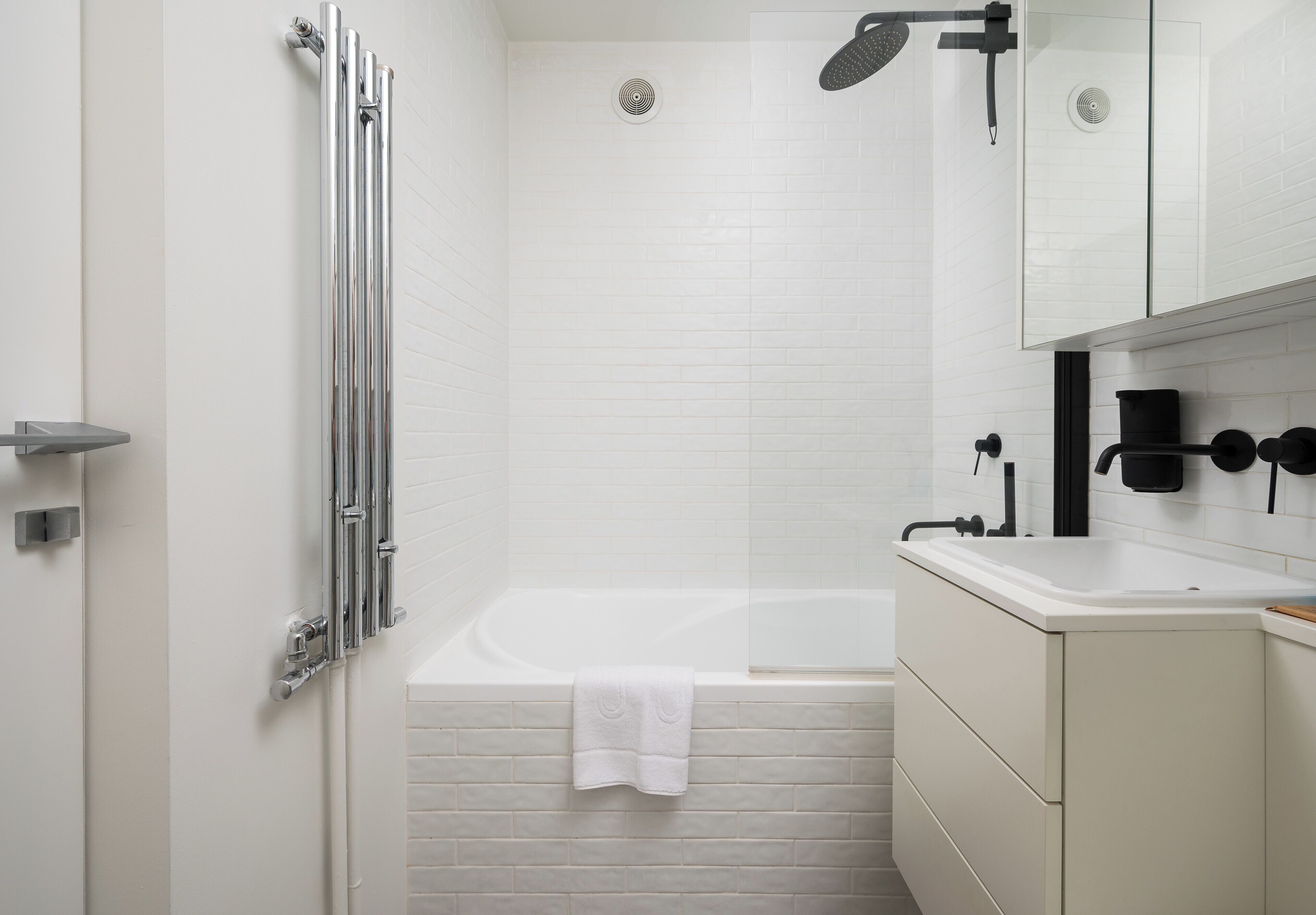 Une salle de bain moderne équipée d’une baignoire, d’une douche et d’un meuble-lavabo.