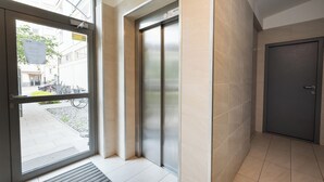 Un ascenseur moderne dans un couloir, avec une porte et une fenêtre.
