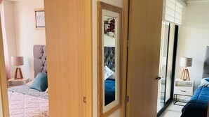A modern bedroom with a large bed, a bedside table, and a wardrobe. - Arcos Vallarta 2be/2ba/1parking (Guadalajara)