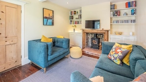 A living room with two sofas, a fireplace, a TV, and bookshelves. - Olive Cottage, Wickham Market (Wickham Market)