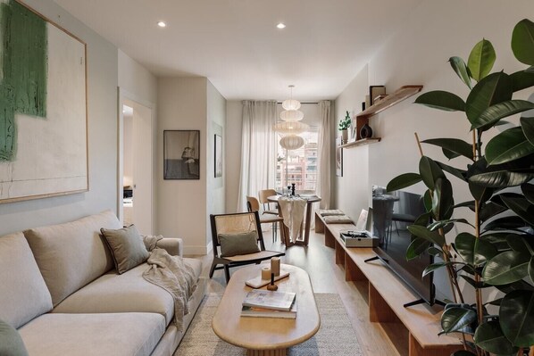 Relax in this inviting living room with a comfortable sofa, dining area, and large window.