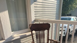 Una silla de madera sobre una cubierta de madera con barandillas blancas.