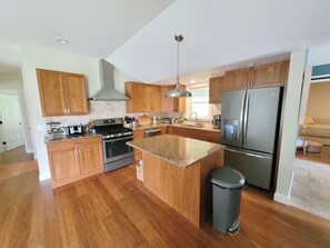 A modern kitchen with wooden cabinets, stainless steel appliances, and a granite countertop. - Clean, perfect home a mile from historic Waterbury (Waterbury Village Historic District)