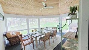 A dining area with a wooden ceiling, a ceiling fan, a table set for four, and a view of the outdoors. - Clean, perfect home a mile from historic Waterbury (Waterbury Village Historic District)