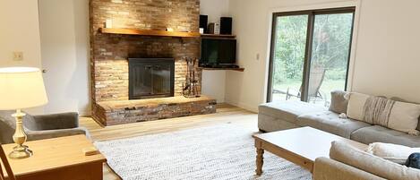 Smart-tv, eldstad, ett bordtennisbord och böcker