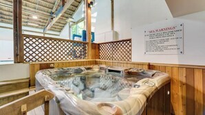 A spa area with a hot tub, wooden walls, and a sign listing SPA WARNINGS. - Stunning views of Stowe, two bedroom, location! (Stowe)