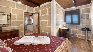 Una camera da letto con un letto, una cassettiera in legno, una lampada e una finestra.