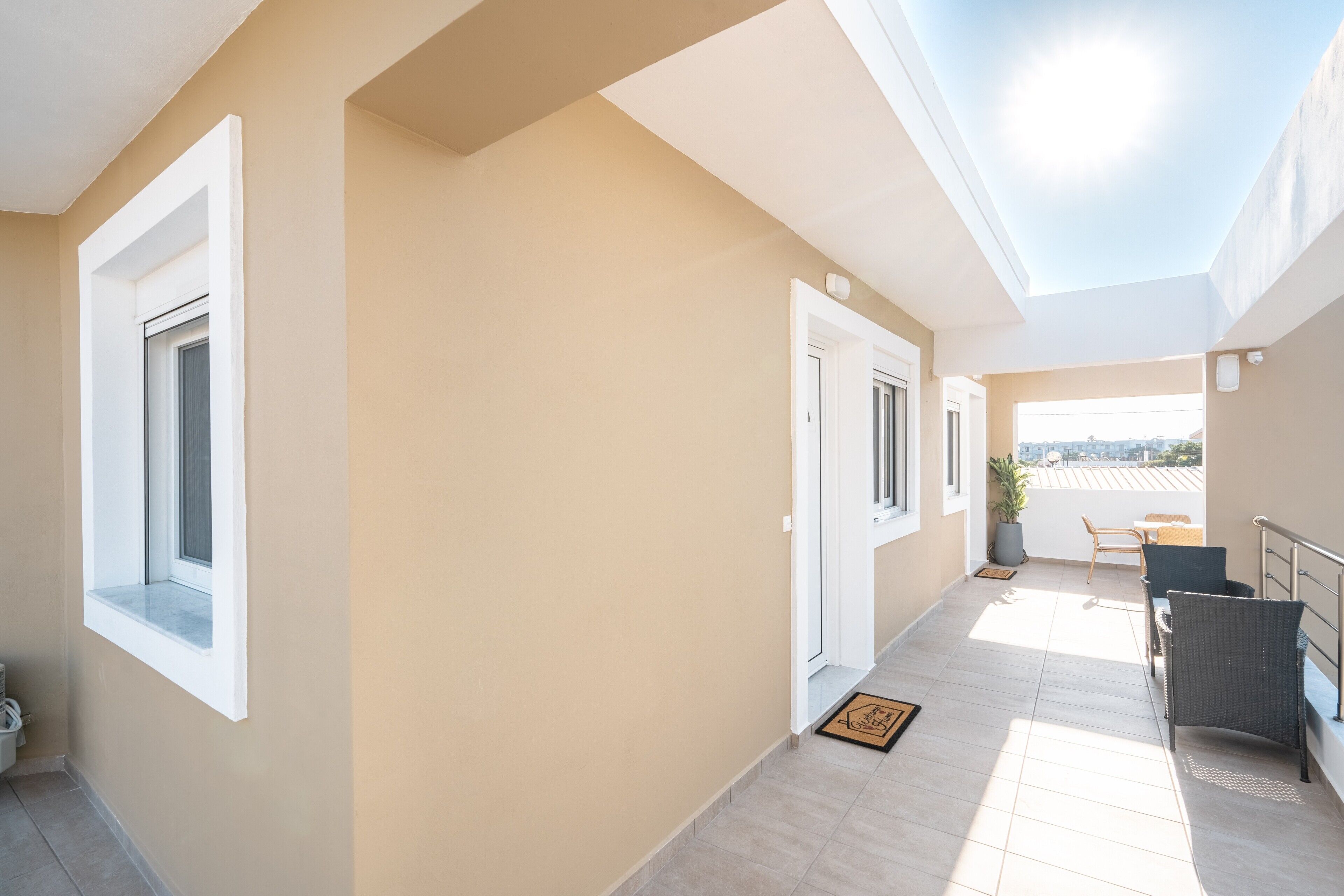 A corridor with a view to a balcony, a door, and a window.