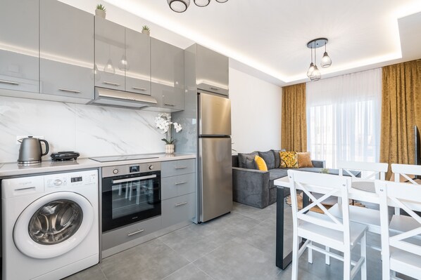 A modern kitchen with a built-in washing machine, oven, and refrigerator.
