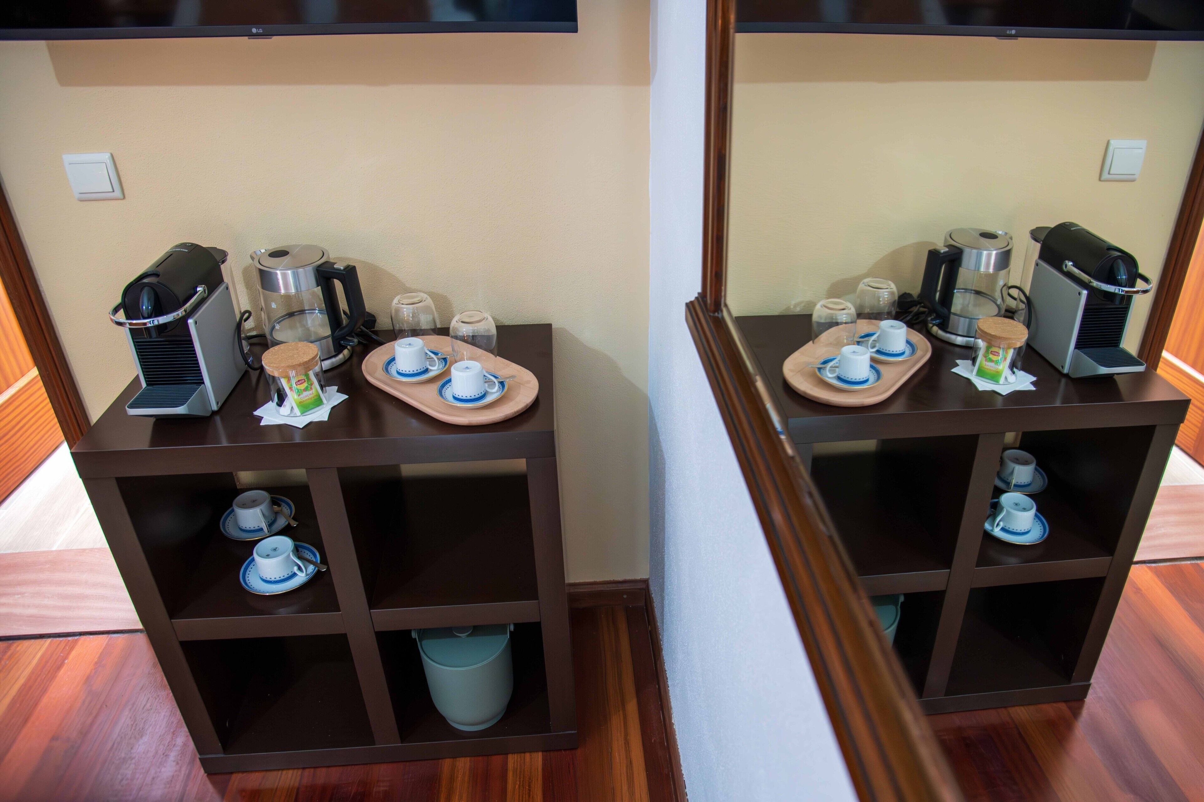 Quarto com espaço para café, incluindo cafeteira, xícaras e pireses.