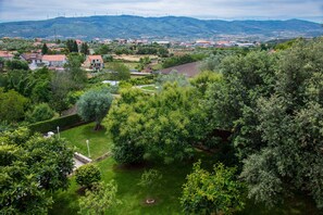 Ett bostadsområde med hus, träd och vindkraftverk i fjärran.