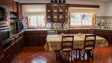Una cocina con armarios de madera, una mesa de comedor con sillas y una ventana con vistas.