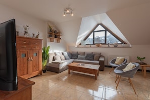 Un salon comprenant un meuble en bois, un canapé, une table basse et un téléviseur.