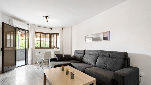 Un salon moderne comprenant un canapé, une table basse et un coin repas avec une chaise et une table.
