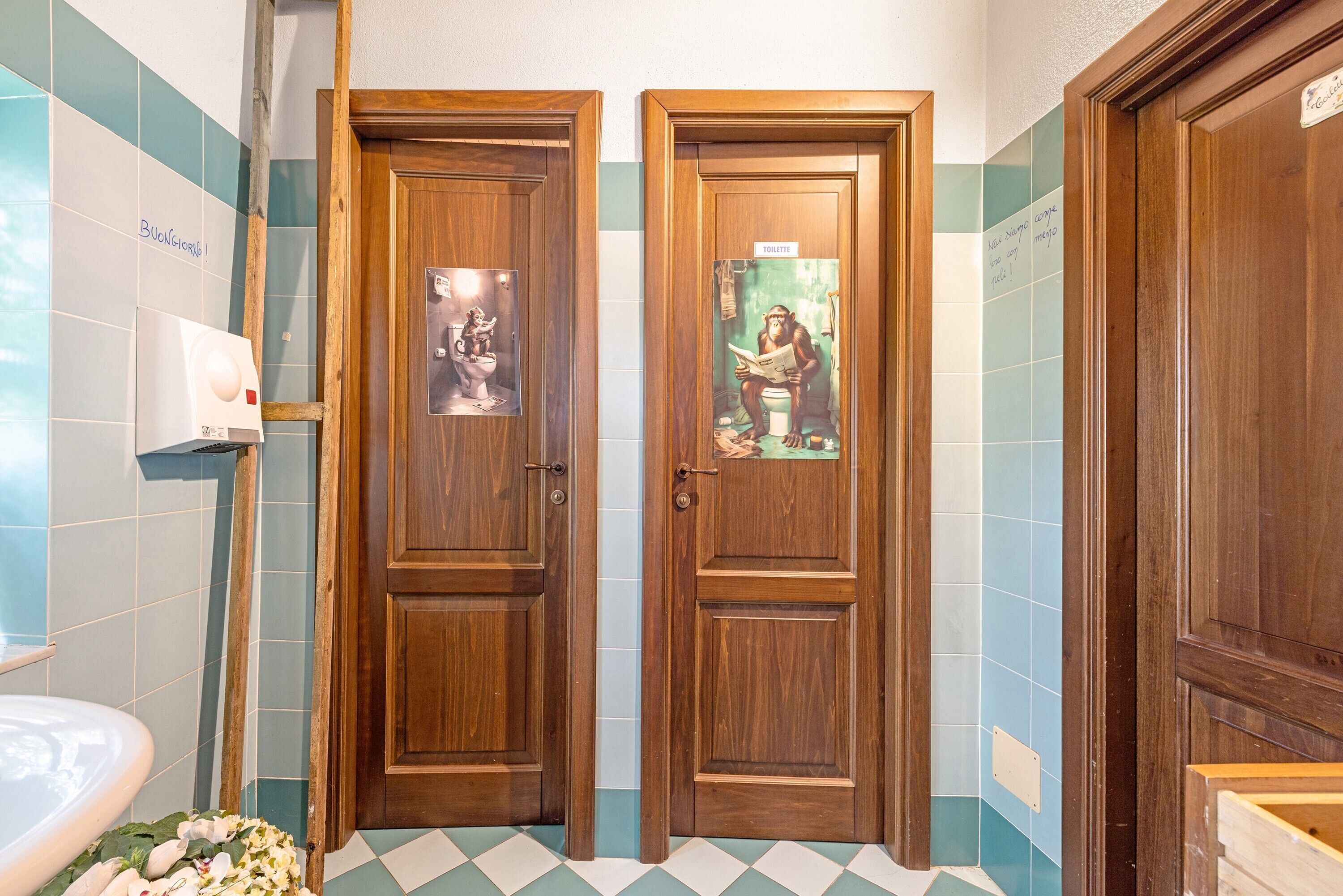 Une salle de bain avec deux portes en bois, un distributeur de papier toilette et un sol carrelé.