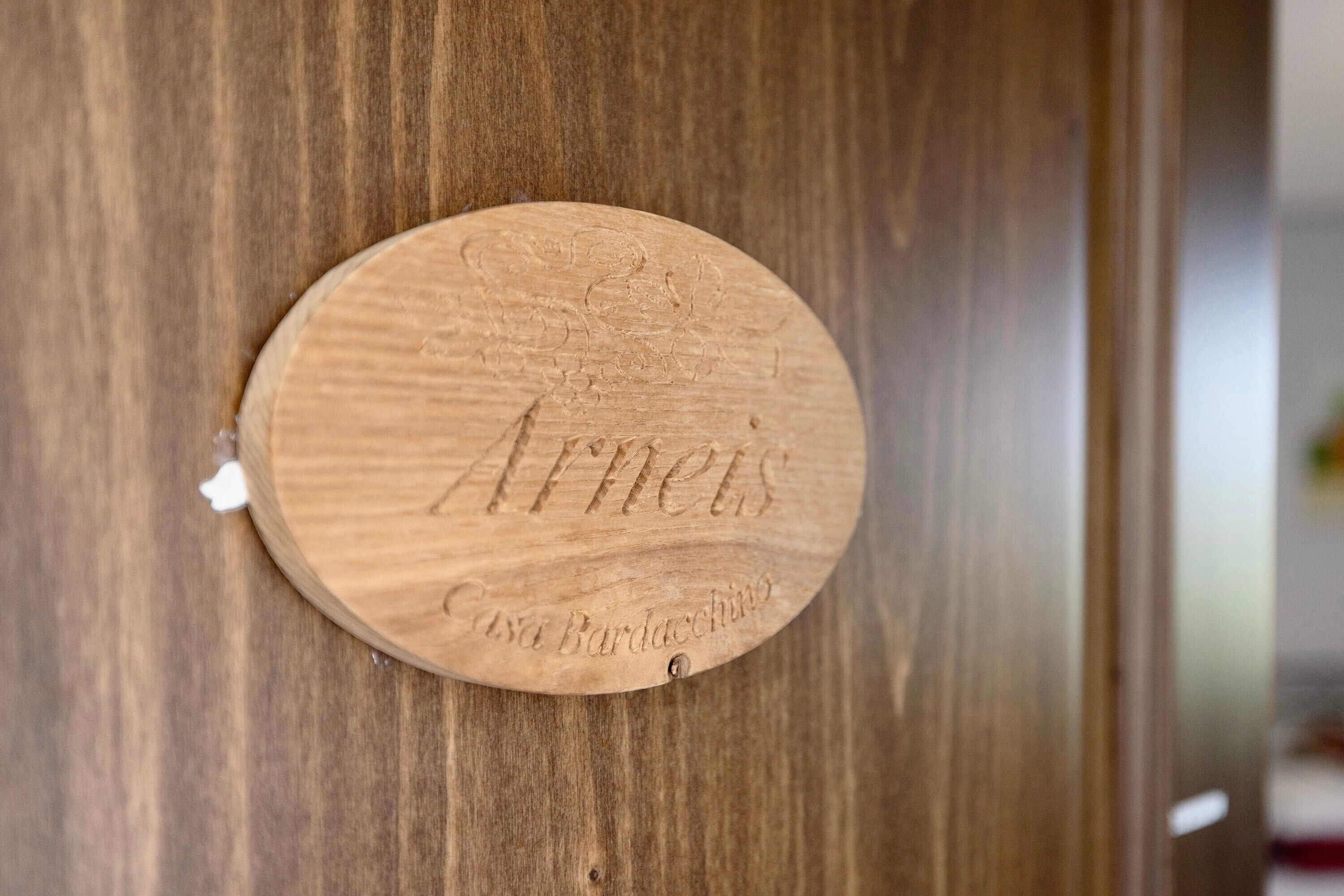 Een houten plaquette met de namen 'Arneis' en 'Casa Barduccino' gegraveerd.