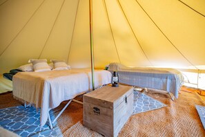 A tent with two beds, a wooden chest, and a lantern.