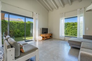 Un ampio soggiorno con un divano, una televisione e un mobile in legno.