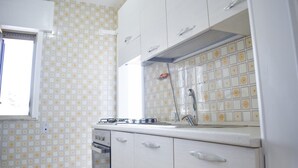 A kitchen with white cabinets, a gas stove, and a tiled backsplash.
