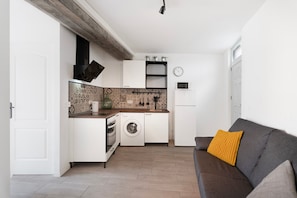 A compact kitchen with white cabinets, a washing machine, and a microwave. - Apartment 'Apartamento La Pista Sur' with Sea View, Private Terrace and Wi-Fi (San Sebastian de la Gomera)