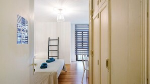 A room with a bed, a chair, a ladder, and a wardrobe. - Vacation Home 'Casa Brando' with Balcony and Wi-Fi (Corralejo)