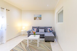 Un salon avec un canapé, une table basse et un tableau accroché au mur.