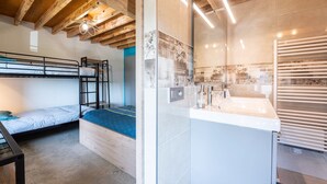 A bunk bed room with a wooden ceiling, a bathroom with a large mirror, and a sink. - Bed and breakfast "Chambre Bleue" with Mountain View, Private Terrace and Shared Garden (Moye)