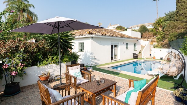 A poolside area with a table and chairs, a hanging chair, and a potted plant. - Holiday Home 'Casa Cerro Del Aguila' with Mountain Views, Wi-Fi and Air Conditioning (CERROS DEL AGUILA)