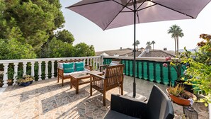 A patio with outdoor furniture, a large umbrella, and potted plants. - Holiday Home 'Casa Cerro Del Aguila' with Mountain Views, Wi-Fi and Air Conditioning (CERROS DEL AGUILA)