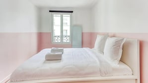 Ein Schlafzimmer mit einem Bett, Kissen und einem Fenster.