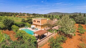A villa with a swimming pool, outdoor seating, and a view of the surrounding countryside. - Villa 'Sa Cova' with Private Pool, Wi-Fi and Air Conditioning (Illes Balears)