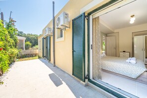 Quarto de hotel com cama, banheiro e vista para a rua.