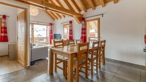 A dining area with wooden furniture, a television, and a view of the outside.