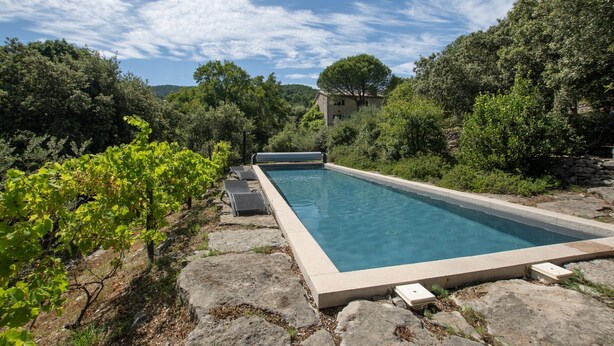 A rectangular pool with a stone border, surrounded by greenery and a stone wall. - Villa 'L'Elzède' with Mountain Views, Private Pool and Wi-Fi (Les Vans)