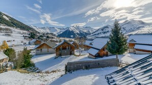 A snow-covered village with wooden cabins, a wooden fence, and a mountain backdrop. - Apartment 'La Grande Vadrouille' with Mountain View, Shared Terrace and Wi-Fi (Saint Jean d'Arves)
