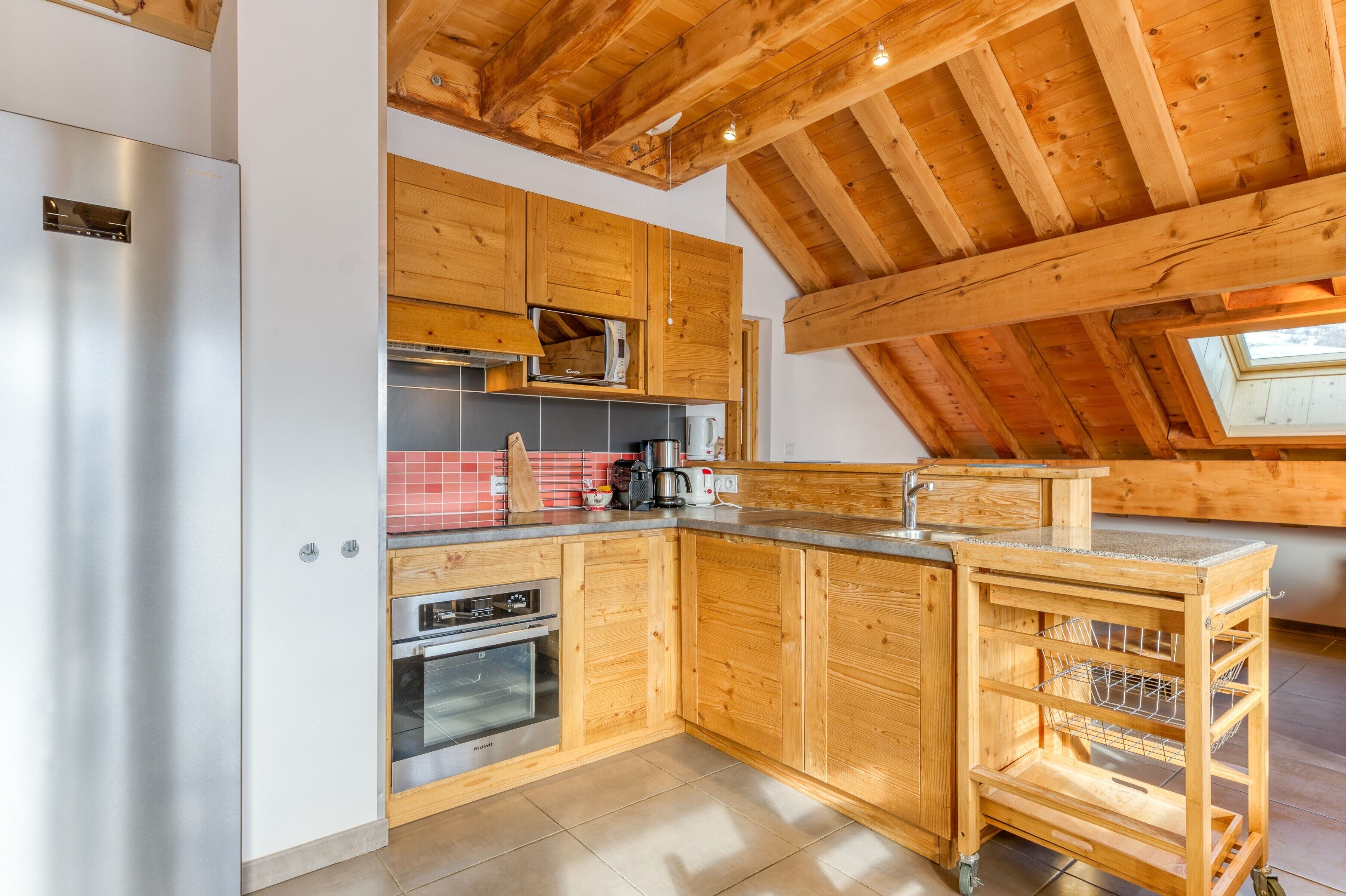 Une cuisine moderne avec des meubles en bois, des appareils électroménagers en acier inoxydable et un puits de lumière.