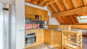 A modern kitchen with wooden cabinets, stainless steel appliances, and a skylight. - Apartment 'La Grande Vadrouille' with Mountain View, Shared Terrace and Wi-Fi (Saint Jean d'Arves)