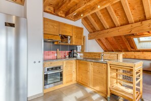 Uma cozinha moderna com armários de madeira, eletrodomésticos de aço inoxidável e um claraboia.