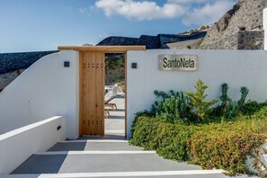A white building with a wooden door and a sign reading 'SantoNeta.'