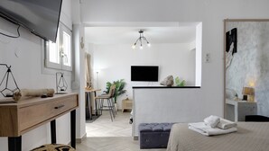 Een moderne hotelkamer met een bed, bureau, televisie en een zithoek.