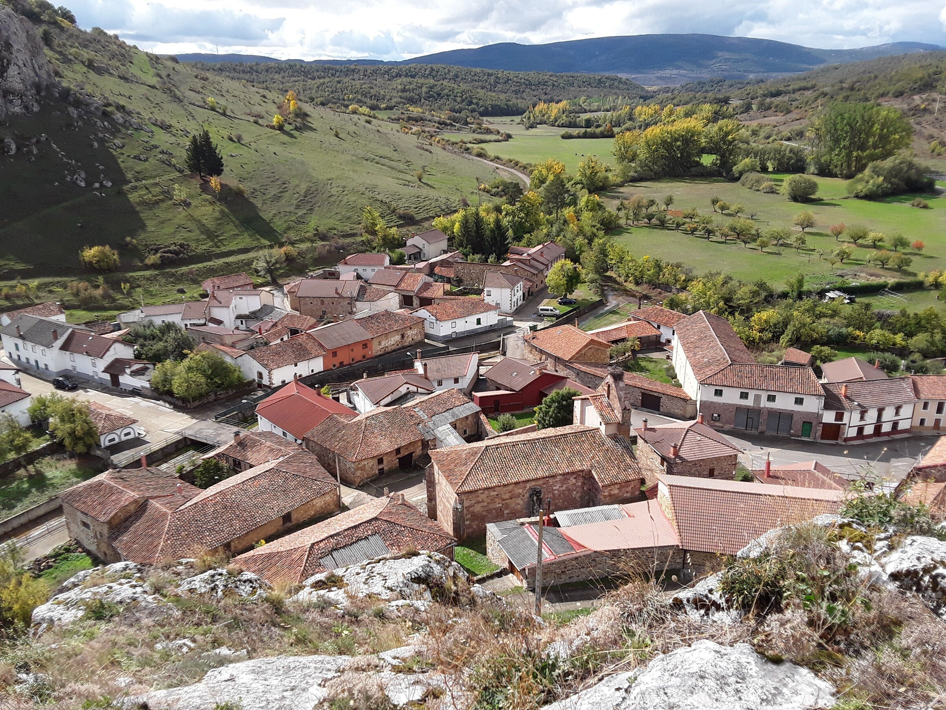A village with traditional architecture, cobblestone streets, and a hilly backdrop.