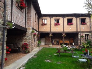 A courtyard with a stone building, potted plants, and outdoor seating. - Country House 'Nido Patio' with Mountain View, Shared Terrace and Wi-Fi (Mudá)