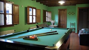 Een pooltafel met ballen, houten kasten en een radiator.