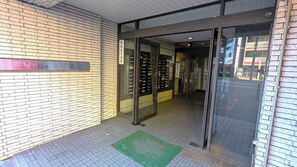 Enter a stylish lobby with a glass door, tiled floor, and a welcoming mat.