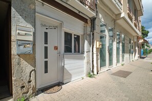 Un edificio con una puerta blanca cerrada, un buzón y un cartel de no estacionamiento.