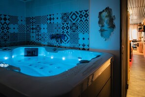 Un jacuzzi con una pared de azulejos al fondo.